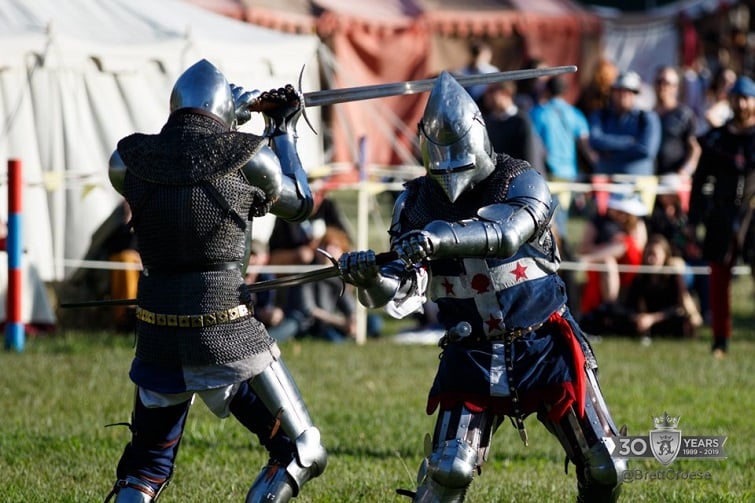 Abbey medieval festival image of two knights n amour fighting with swords.