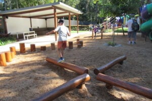 Boy balancing on wooden beams at Amaze World.