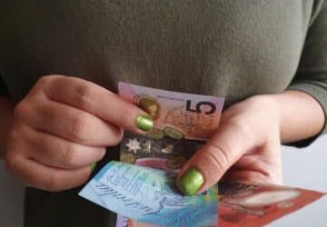 Lady holding Australian currency. five dollar note