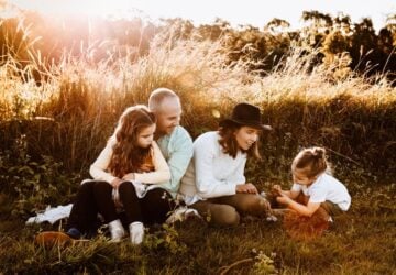 Sev Coban Photography family of four sitting in grass.