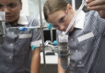 Street Science school incursions girl in school uniform practicing science experiment.
