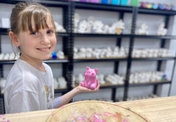 Blank Space Art Studio smiling girl with painted pig.