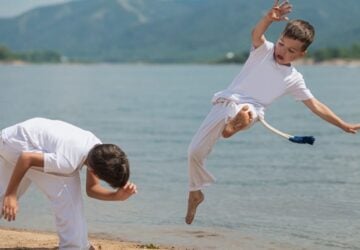 Empowerall Abilities two children capoeira on the beach.