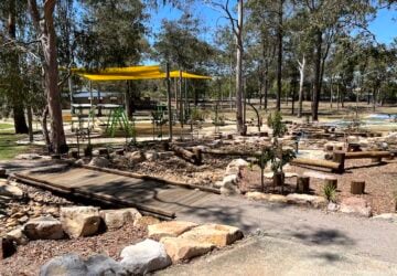 Bridge over dry creek bed with trees in the background at Eridani Park.