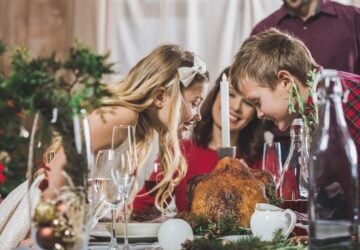 Family Christmas celebration around table with food.