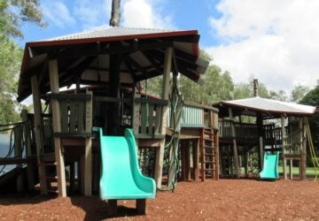 Large wooden fort with two green slides at Kalinga Park.