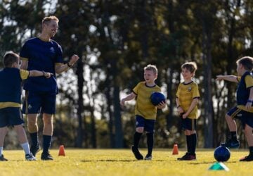 Ginger Sport young soccer players with coach.