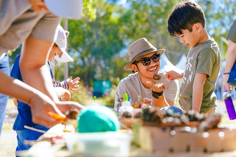 Green heart fair image of father and son doing a craft activity at the fair.