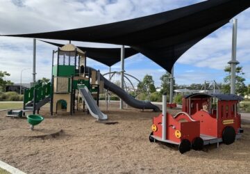Shade sails covering fort and toy train at Guilfoyles Park.