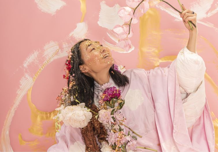 Hiromi Tango artist in residence event image of artist in flowers and paint.