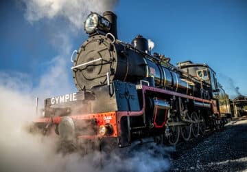 The Mary Valley Rattler steam train surrounded by blue skies and steam.
