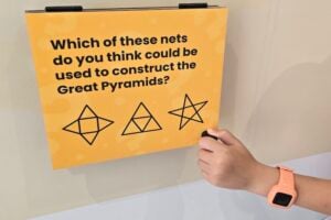 A child's hand opening a flip board at The Mathema Gallery.