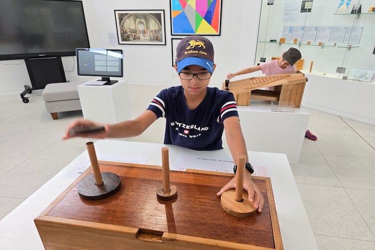 Two children playing with the hands-on activities at The Mathema Gallery.