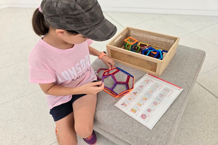 A young girl playing with magnetic tiles at The Mathema Gallery.
