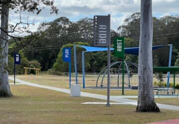 Play, ride, walk and rest signs along pathway at Noyer Park.
