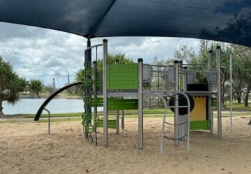 Play equipment with sand base under shade sail at Raby Bay Boulevard Park.