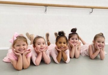 Radiance Dance smiling young ballerinas on floor.
