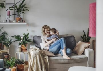 Mother and child on lounge chair surrounded by plants