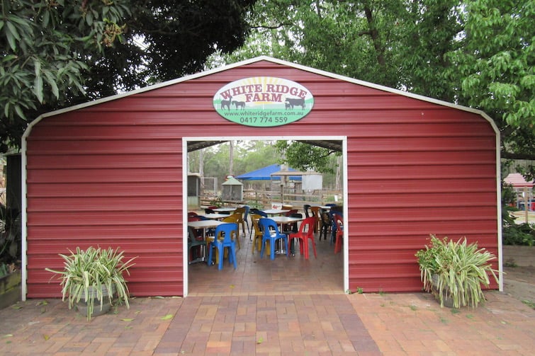Maroon shed with White Ridge Farm sign on it.