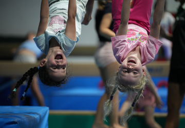 Balance Brisbane children hanging upside down from beams.
