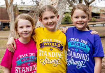 Lemonade Kids group of students embracing at workshop.