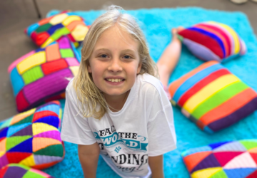 Teacup Coach smiling child on colourful rug.